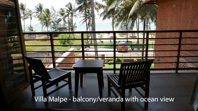 View of ocean from upper level balcony with chairs and table