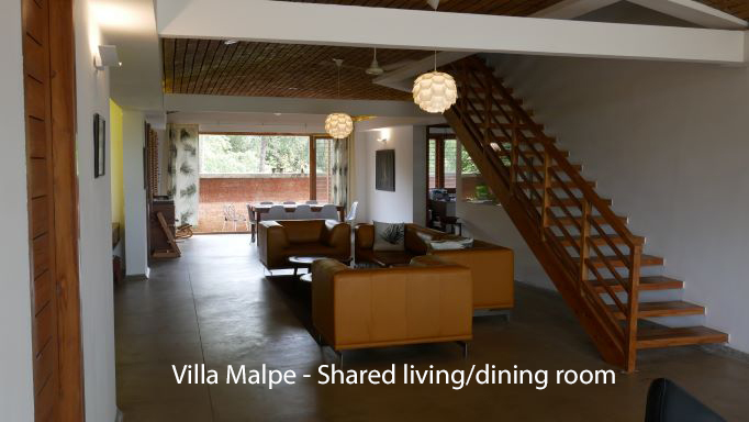 Sofa with dining room and stairs in background