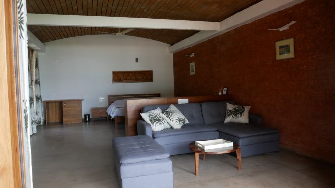Sofa/bed and table in foreground and king size bed in background